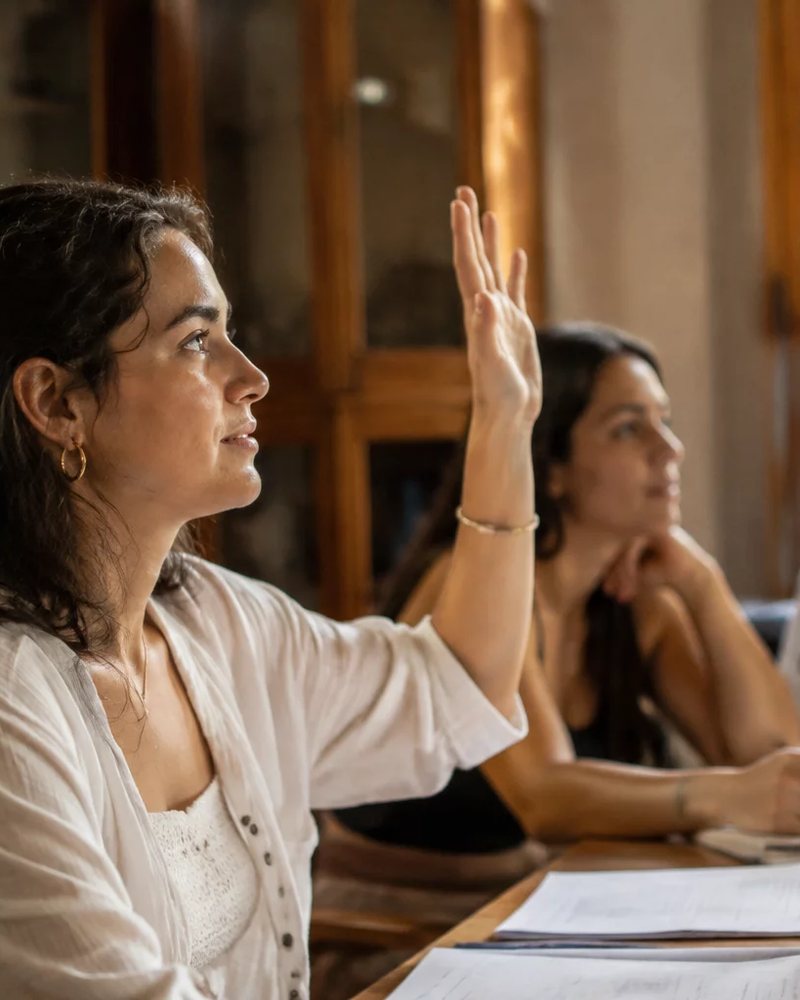 Dupla preparando uma rodada de debate, com cadernos e canetas espalhados na mesa